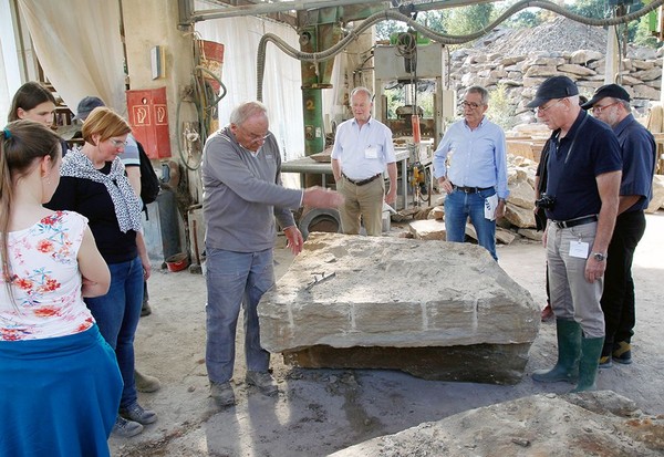 Auf dem Bild sehen wir, wie den Teilnehmern im Steinbruch anhand eines großen Sandsteins etwas erklärt wird