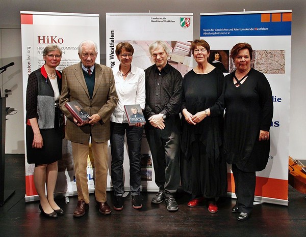 Auf dem Bild sehen wir ein Gruppenfoto der Herausgeber und Musiker