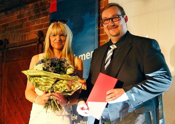 Auf dem Bild zu sehen ist Frau Doktor Rüschoff-Parzinger, die den Preis an Doktor Spannhoff übergiebt.
